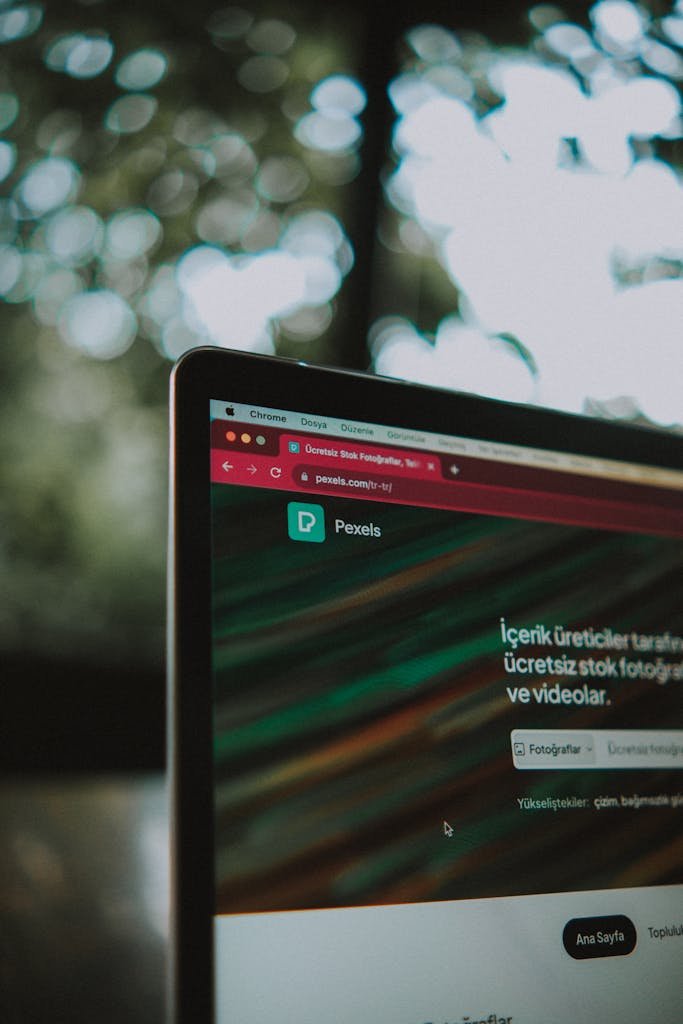 Close-up of a laptop screen with the Pexels website open, showcasing a vibrant bokeh background.